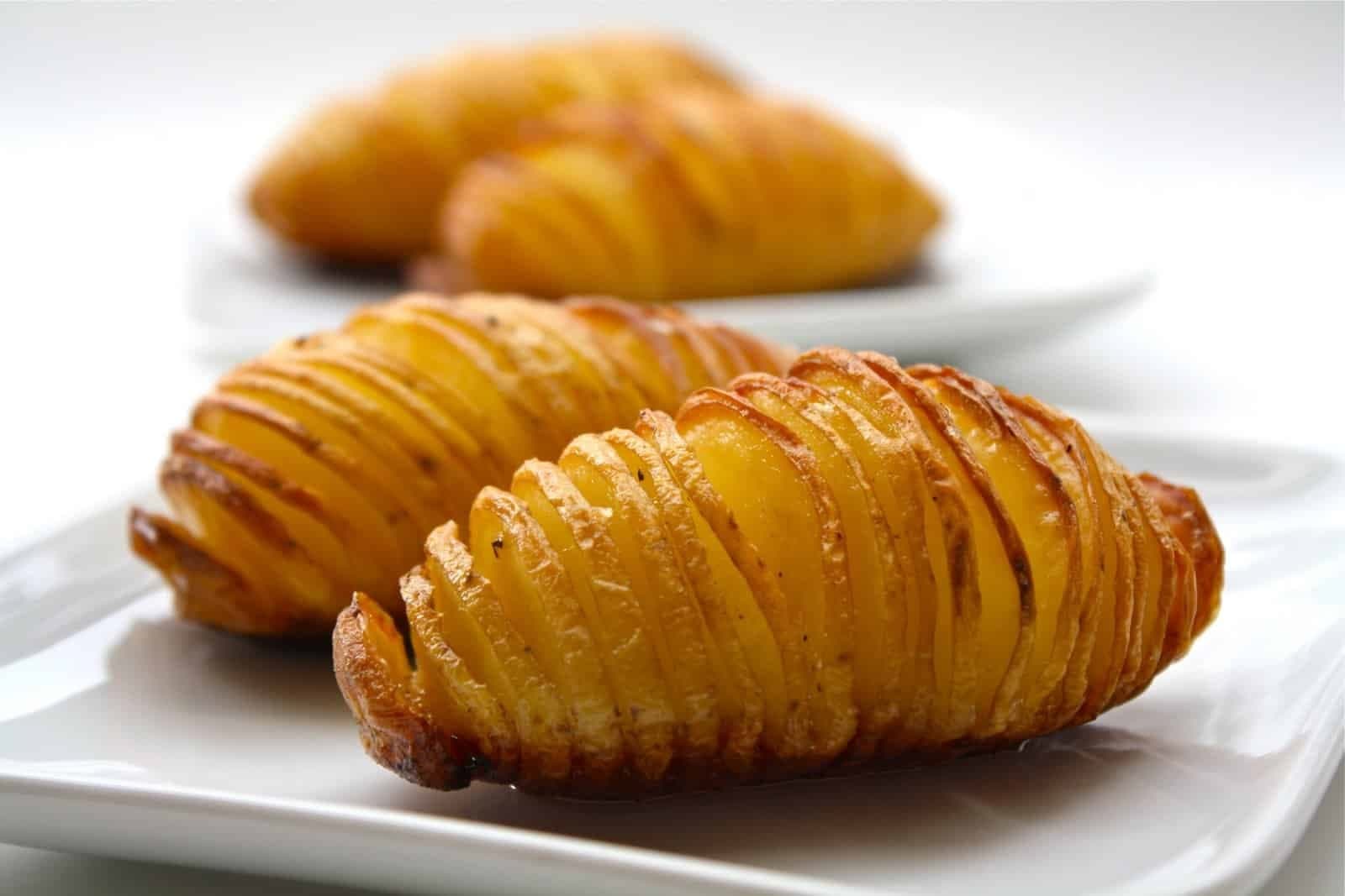 Hasselback potatoes baked until crispy on the outside and tender on the inside, sliced thinly and roasted with butter, olive oil, garlic, sea salt, and black pepper.