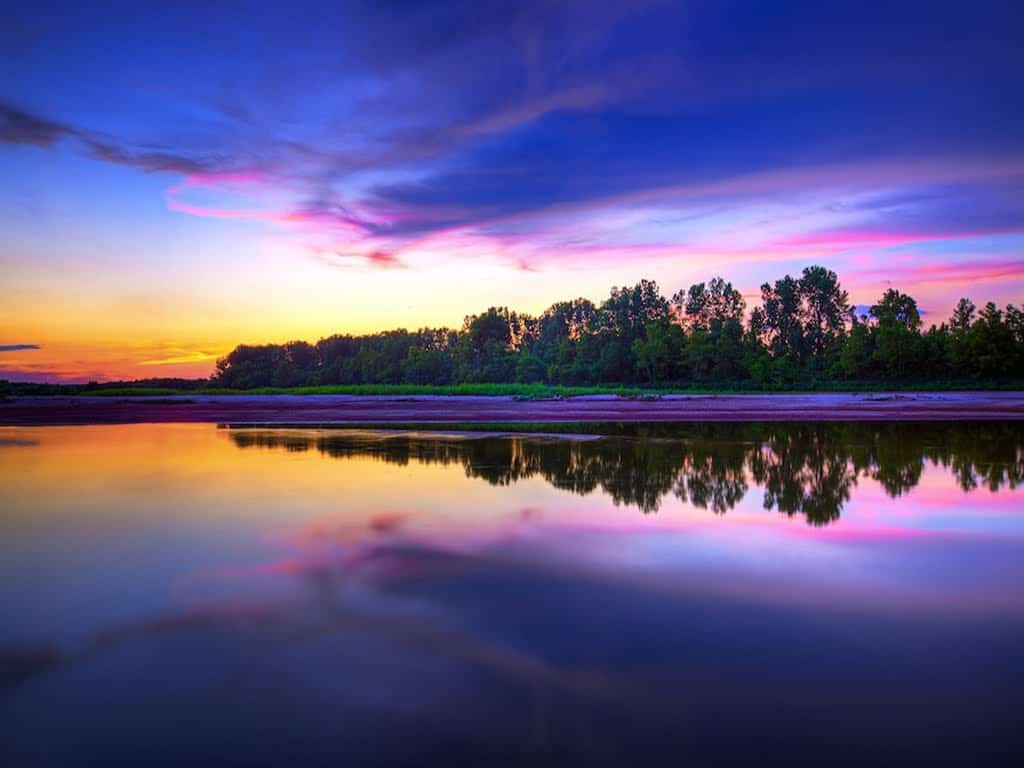 Peaceful sunset reflected on still water, symbolizing spiritual connection, inner harmony, and unity within separateness.