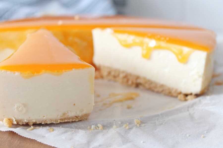 Slices of homemade apricot cheesecake with a golden apricot glaze on a cookie crust