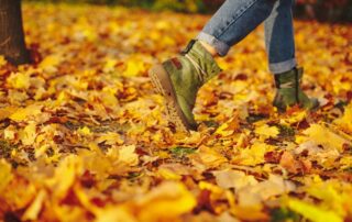 A person walking through golden autumn leaves on a forest path, symbolizing mindfulness, exploration, and inner peace.