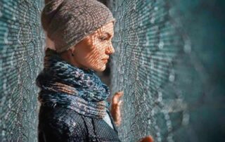 Woman in contemplation of "Why Me?", behind a fence, symbolizing self-reflection, boundaries, and emotional healing