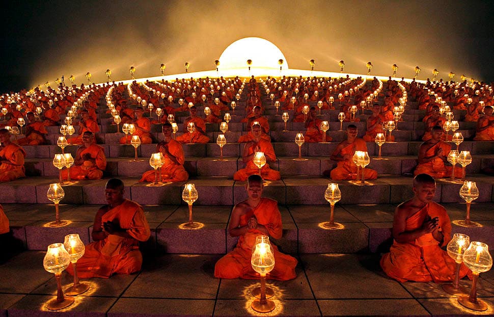 Monks gathering together in candlelight at Wat Phra Dhammakaya - The Most Amazing Buddhist Temple in Pathum Thani, Thailand