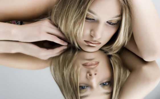 Woman reflecting in mirror representing low self esteem, self image struggles, and rebuilding self worth