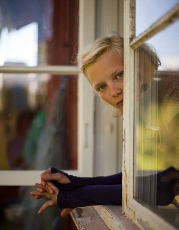 A woman looking out a window with quiet strength, symbolizing vulnerability, honesty, and emotional courage.
