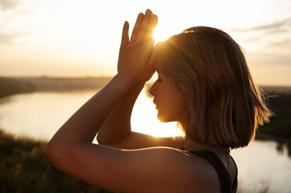 Young woman in quiet reflection at sunset, symbolizing living consciously, inner awareness, and presence
