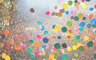 Colorful balloons rising above a joyful crowd, symbolizing release, renewal, and the freedom of spirit