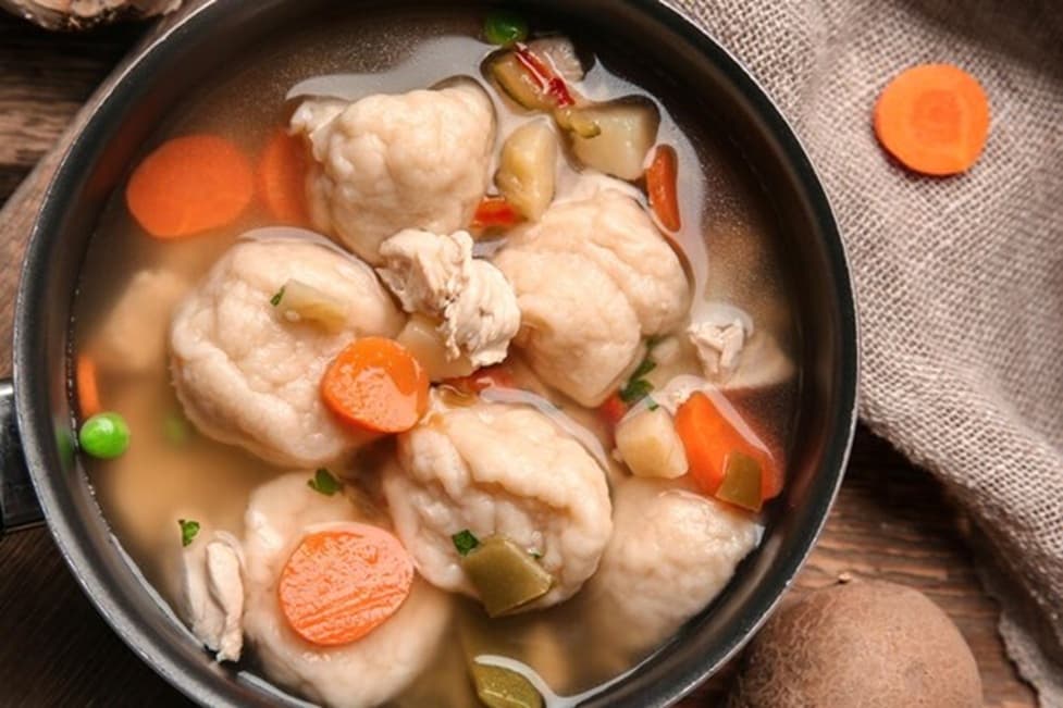 Bowl of slow cooker chicken and dumplings with carrots, peas, and tender dumplings