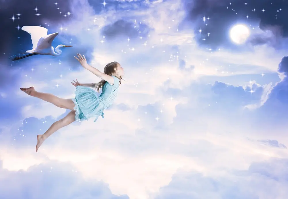 Person flying through a dreamlike sky, symbolizing different types of dreams and dream awareness