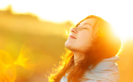 Woman basking in sunlight, feeling inner peace and spiritual awakening
